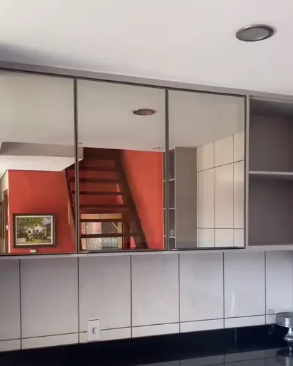 Cozinha planejada com armários aéreos e painel espelhado