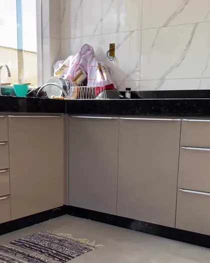 Cozinha planejada em tom fendi com bancada de granito preto