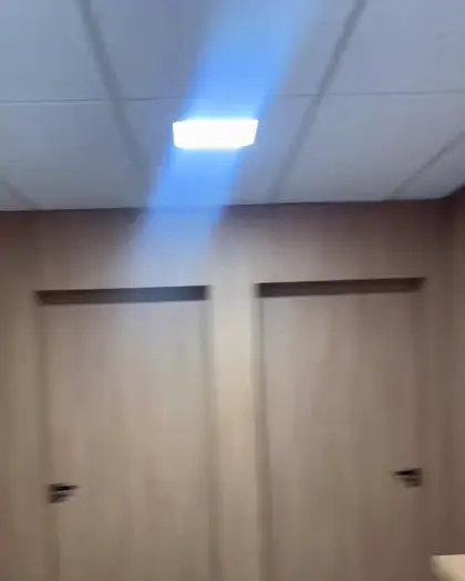 Ambiente com painel ripado amadeirado e portas ocultas